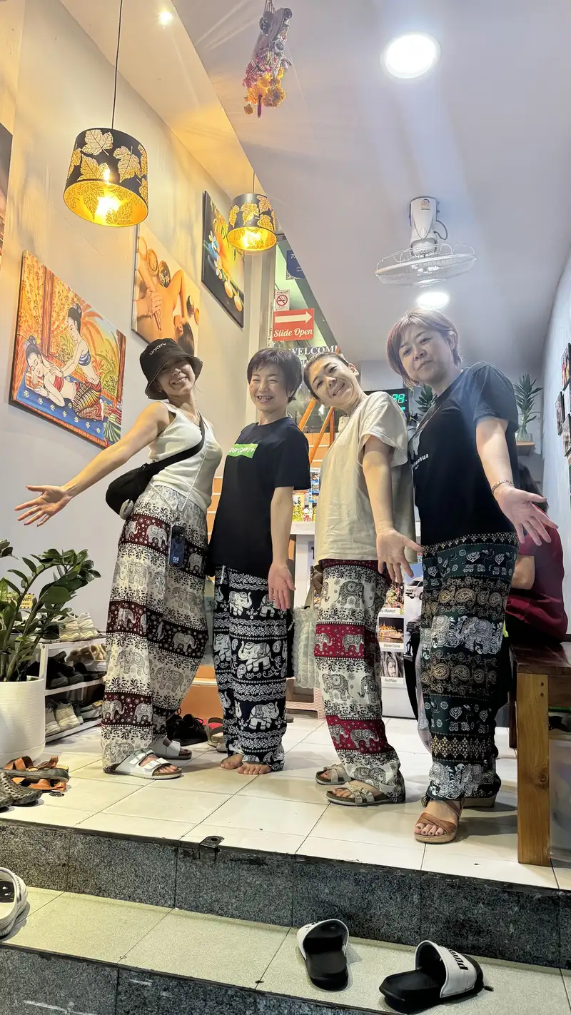 Guests in elephant-print trousers in the entrance hall under the lantern lamps